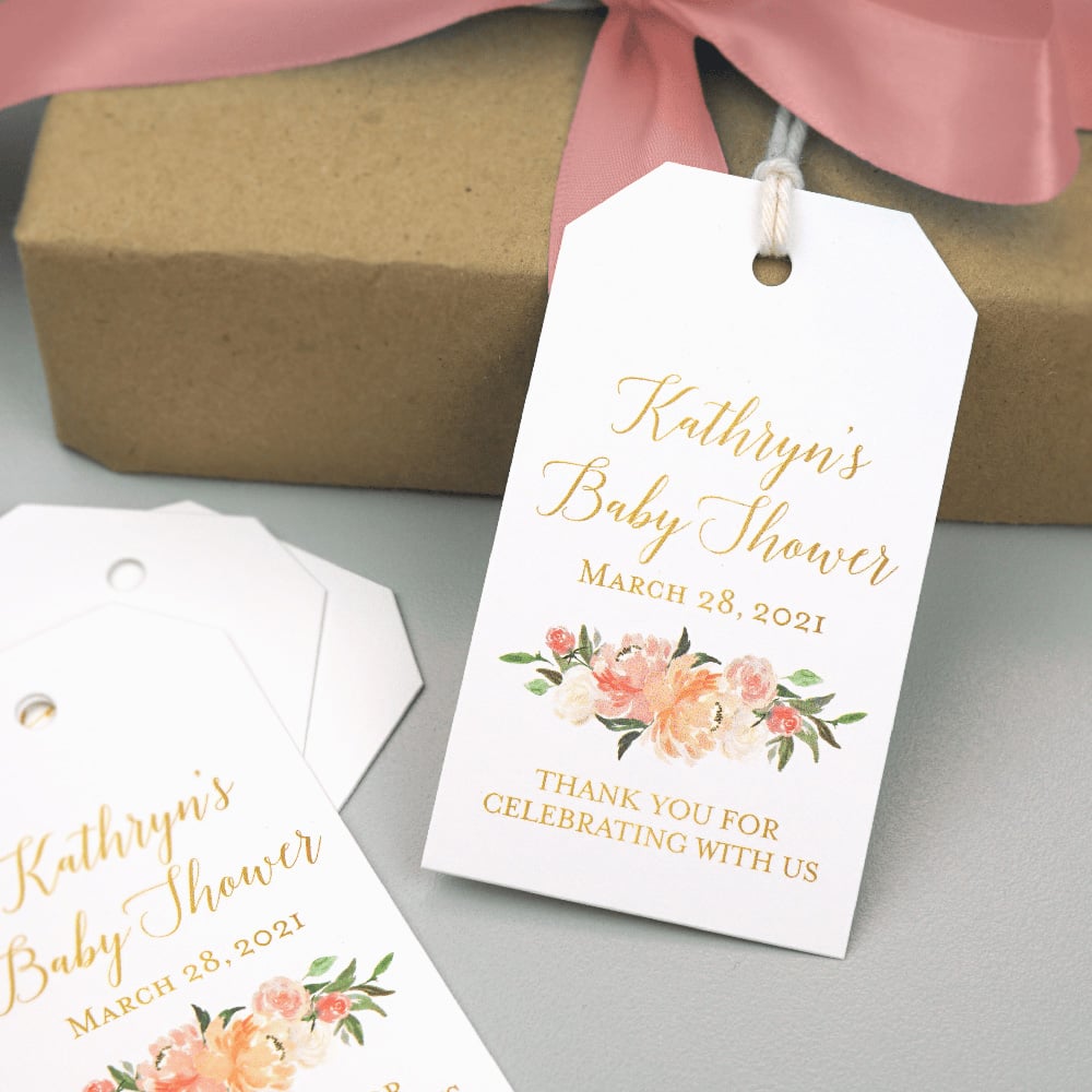 A white tag with gold script that reads "Kathryn's Baby Shower. Thank You for Celebrating With Us"