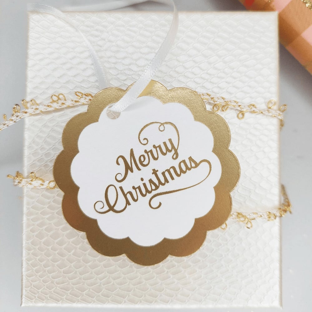 A white and gold tag that reads "Merry Christmas"